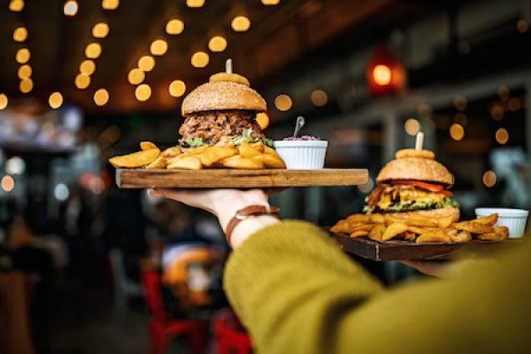 burgers being carried to a table in a restaurant