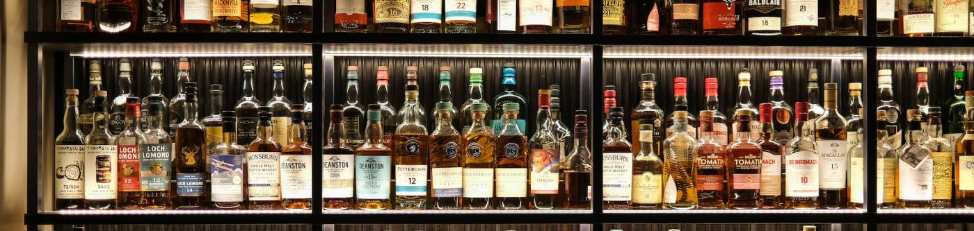 Shelves of alcohol behind a bar